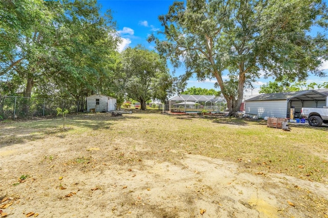106 8th St, Lake Hamilton, FL 33851 - view of yard featuring a detached carport, a storage unit, and an outdoor structure