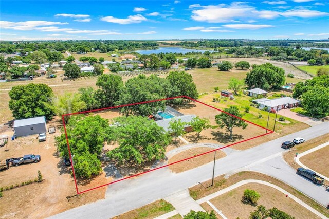 106 8th St, Lake Hamilton, FL 33851 - aerial overview of property's location with a large body of water, property boundaries highlighted, and a tree filled landscape