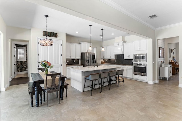 557 Lake Cove Pointe Cir, Winter Garden, FL 34787 - kitchen featuring stainless steel appliances, decorative backsplash, baseboards, a kitchen bar, and crown molding