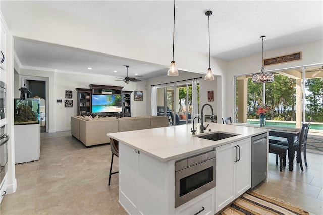 557 Lake Cove Pointe Cir, Winter Garden, FL 34787 - kitchen featuring a sink, appliances with stainless steel finishes, white cabinetry, pendant lighting, and a kitchen island with sink