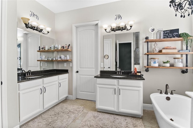 557 Lake Cove Pointe Cir, Winter Garden, FL 34787 - full bath featuring two vanities, a freestanding bath, and baseboards