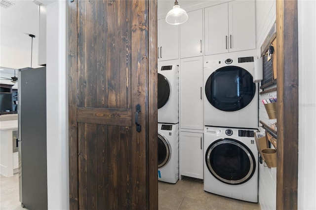 557 Lake Cove Pointe Cir, Winter Garden, FL 34787 - washroom featuring stacked washer / drying machine, cabinet space, and light tile patterned flooring