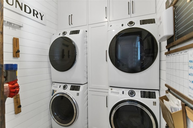 557 Lake Cove Pointe Cir, Winter Garden, FL 34787 - laundry area with stacked washing machine and dryer, cabinet space, and wood walls