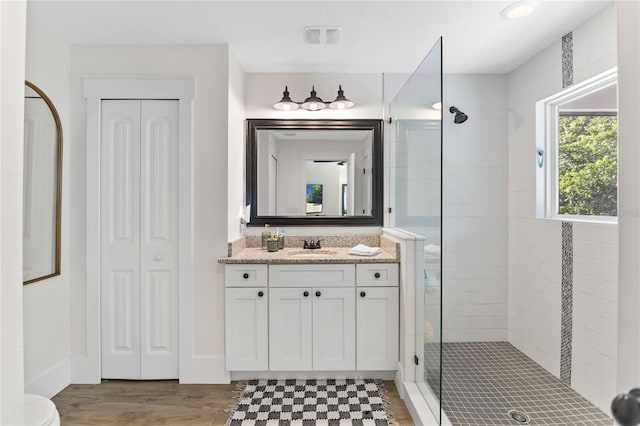 557 Lake Cove Pointe Cir, Winter Garden, FL 34787 - full bathroom with a tile shower, wood finished floors, vanity, a closet, and baseboards