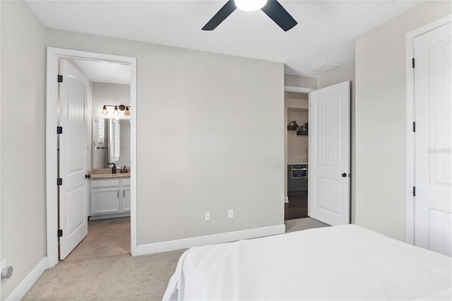 557 Lake Cove Pointe Cir, Winter Garden, FL 34787 - bedroom featuring light colored carpet, baseboards, connected bathroom, and a ceiling fan