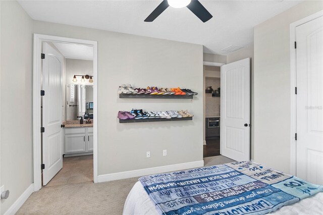 557 Lake Cove Pointe Cir, Winter Garden, FL 34787 - bedroom with light colored carpet, ensuite bath, a ceiling fan, and baseboards