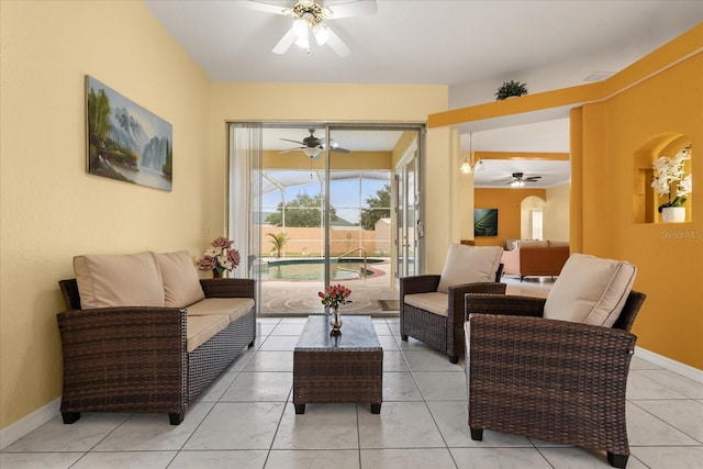 living room featuring a ceiling fan, baseboards, and light tile patterned floors
