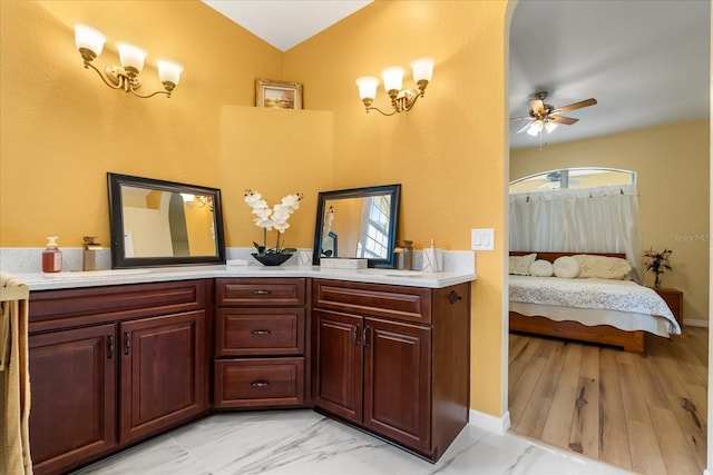 ensuite bathroom with a ceiling fan, vanity, and baseboards