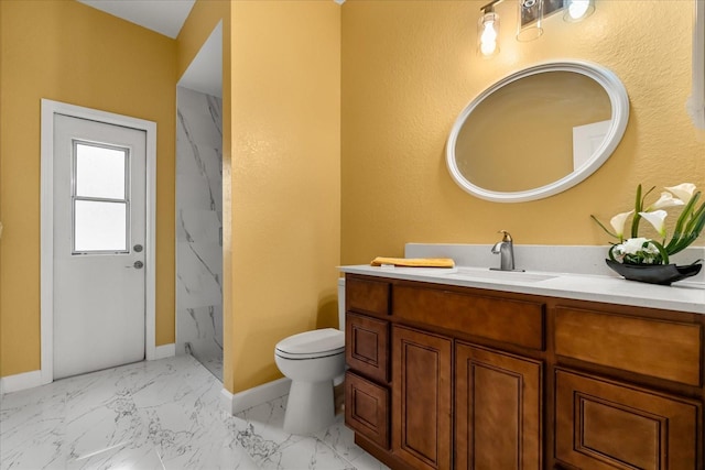 bathroom with baseboards, toilet, vanity, and marble look tiles