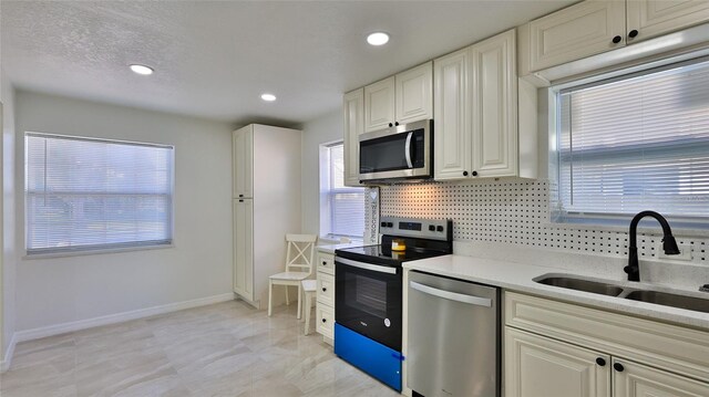 326 Hobart Ave, Daytona Beach, FL 32114 - kitchen with stainless steel appliances, a sink, tasteful backsplash, baseboards, and light stone countertops