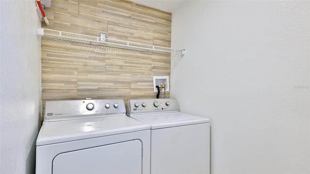 326 Hobart Ave, Daytona Beach, FL 32114 - laundry area featuring washing machine and clothes dryer, wood walls, and a textured wall