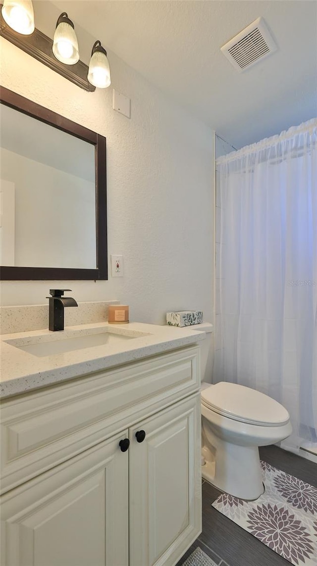 326 Hobart Ave, Daytona Beach, FL 32114 - full bath featuring toilet, vanity, a shower with shower curtain, and wood finished floors