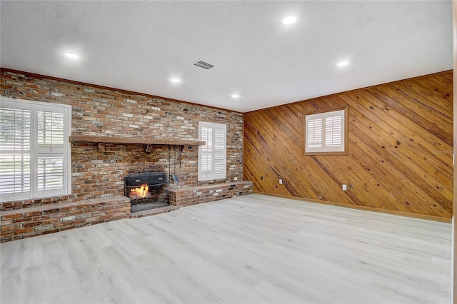 3100 Las Palmas Dr, Titusville, FL 32780 - unfurnished living room featuring plenty of natural light, wood finished floors, brick wall, wood walls, and recessed lighting