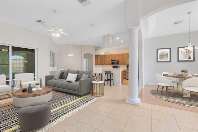 9330 Shadow Pinar Ct, Orlando, FL 32825 - living room with light tile patterned flooring, ornate columns, a ceiling fan, a chandelier, and arched walkways