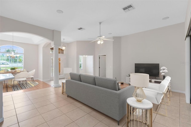 9330 Shadow Pinar Ct, Orlando, FL 32825 - living area featuring arched walkways, decorative columns, light tile patterned floors, and a chandelier