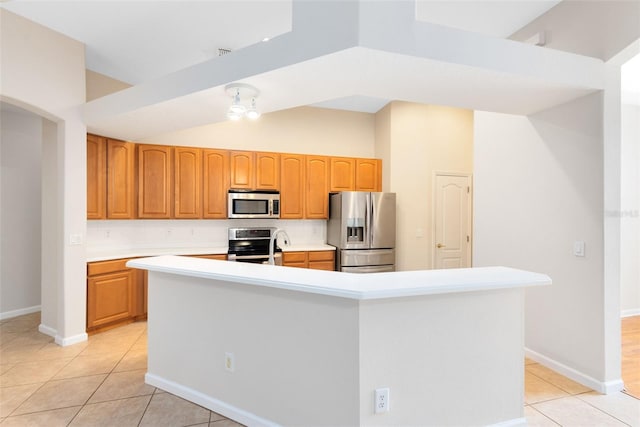 9330 Shadow Pinar Ct, Orlando, FL 32825 - kitchen with appliances with stainless steel finishes, light tile patterned flooring, light countertops, an island with sink, and vaulted ceiling
