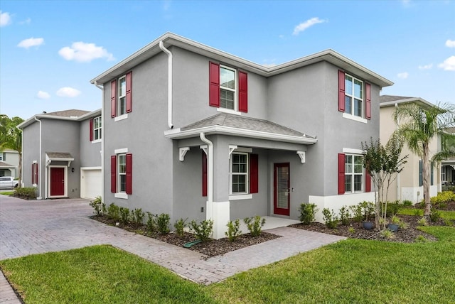 3039 Meleto Blvd, New Smyrna Beach, FL 32168 - view of front of property featuring stucco siding, decorative driveway, a garage, and a front yard