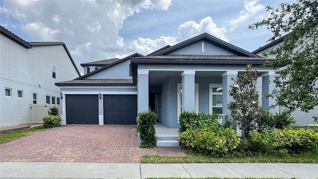 9917 Summerlake Groves St, Winter Garden, FL 34787 - view of front of property featuring decorative driveway, an attached garage, a porch, stucco siding, and a shingled roof