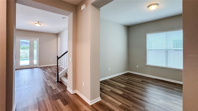 9917 Summerlake Groves St, Winter Garden, FL 34787 - unfurnished room featuring dark wood-style floors, stairs, baseboards, and a textured ceiling