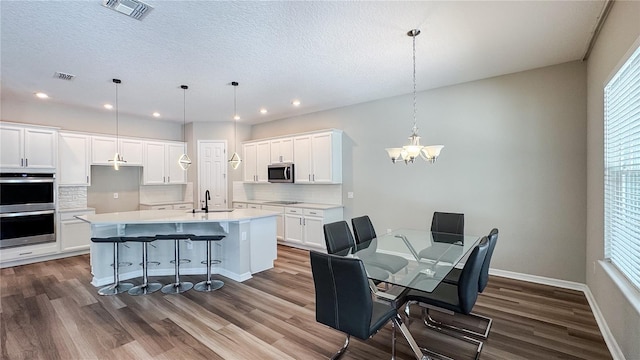 9917 Summerlake Groves St, Winter Garden, FL 34787 - dining room with dark wood-style flooring, a chandelier, baseboards, recessed lighting, and a textured ceiling