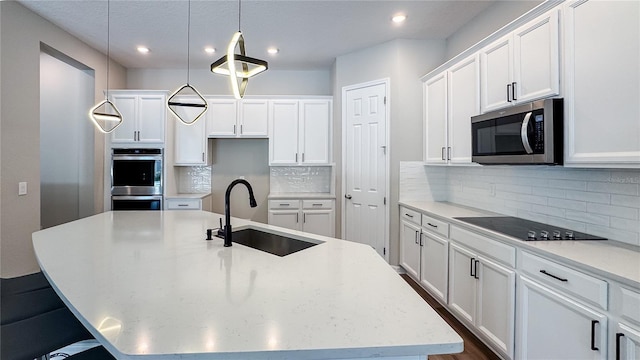 9917 Summerlake Groves St, Winter Garden, FL 34787 - kitchen featuring a sink, appliances with stainless steel finishes, a kitchen island with sink, white cabinetry, and recessed lighting