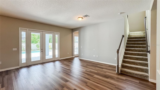 9917 Summerlake Groves St, Winter Garden, FL 34787 - unfurnished living room with wood finished floors, stairway, french doors, a textured ceiling, and baseboards