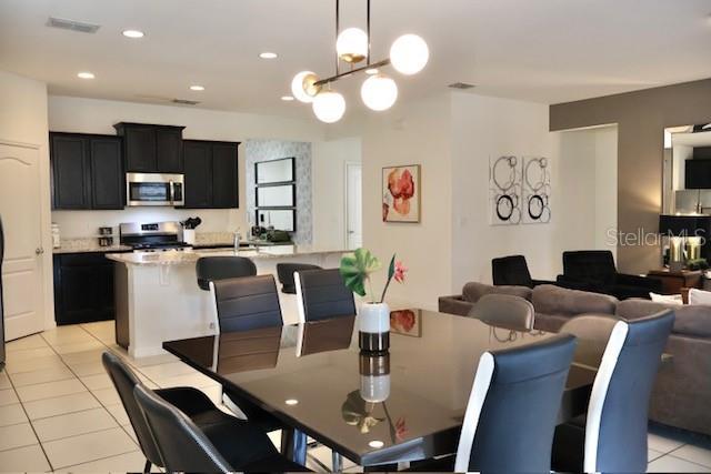 dining area with light tile patterned floors, a chandelier, and recessed lighting