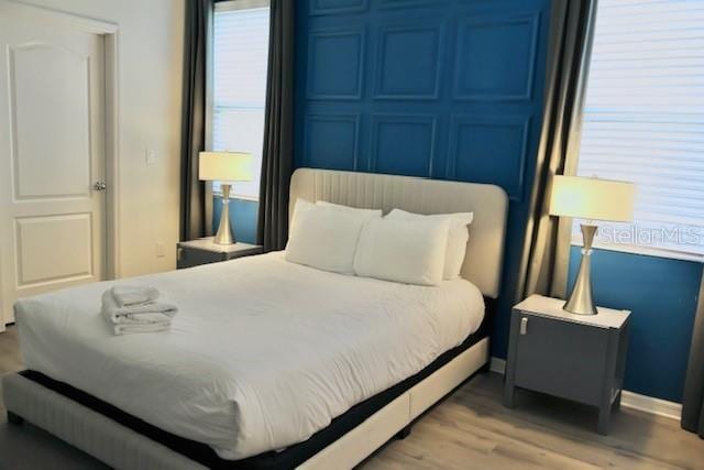 bedroom featuring light wood-type flooring and baseboards