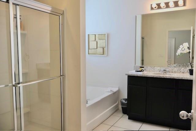full bathroom with a shower stall, tile patterned floors, a bath, and vanity
