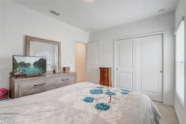 bedroom with a closet and light colored carpet