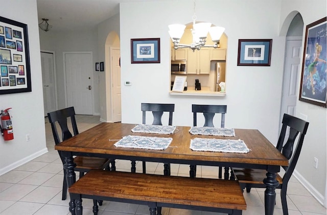 2785 Almaton Loop Unit 204, Kissimmee, FL 34747 - dining room featuring arched walkways, a chandelier, light tile patterned floors, and baseboards