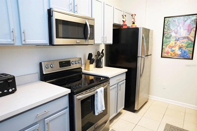 2785 Almaton Loop Unit 204, Kissimmee, FL 34747 - kitchen with stainless steel appliances, light countertops, light tile patterned floors, and baseboards