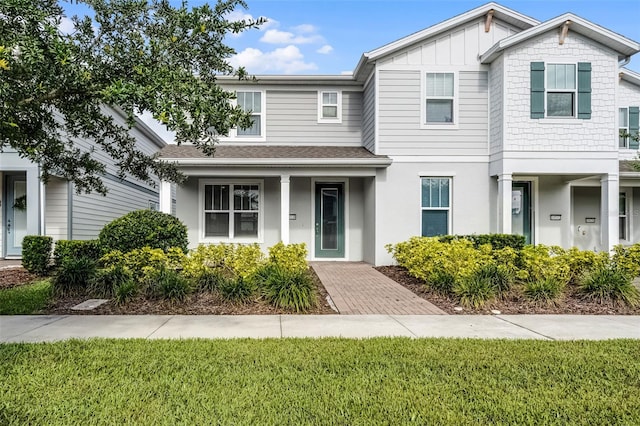 14538 Orchid Island Dr, Orlando, FL 32827 - townhome / multi-family property with a front lawn, board and batten siding, stucco siding, and roof with shingles