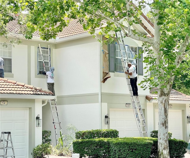 view of side of home with a tiled roof and stucco siding
