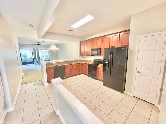 kitchen with black appliances, light tile patterned floors, a peninsula, a chandelier, and a sink