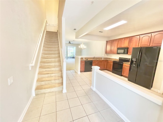 kitchen with black appliances, light tile patterned floors, baseboards, a peninsula, and light countertops