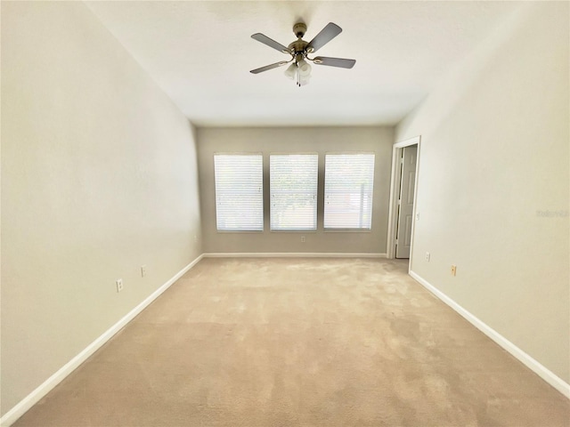 unfurnished room featuring baseboards, light colored carpet, and ceiling fan