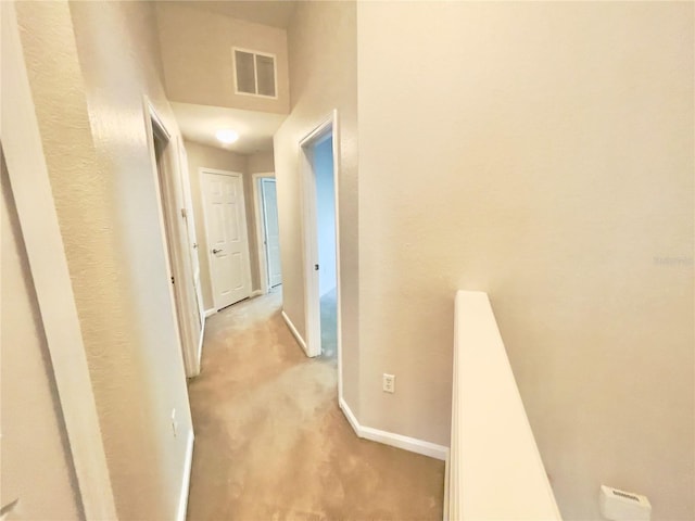 hall featuring light carpet and baseboards