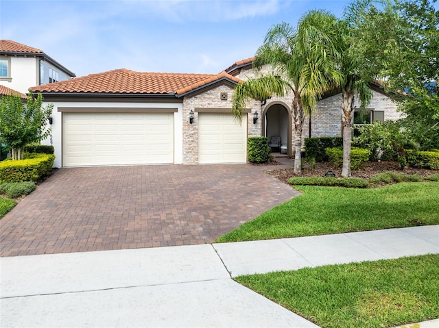 16696 Otterchase Ln, Winter Garden, FL 34787 - view of front of property featuring decorative driveway, an attached garage, a tiled roof, a front lawn, and stucco siding