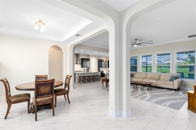 16696 Otterchase Ln, Winter Garden, FL 34787 - dining area with arched walkways, light marble finish floors, a ceiling fan, and baseboards