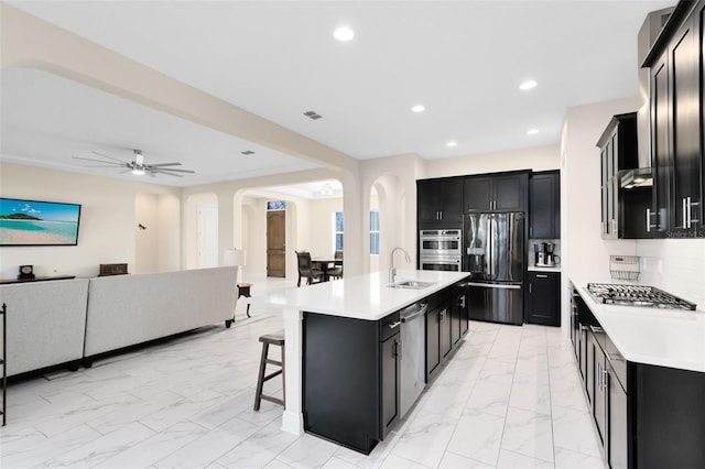 16696 Otterchase Ln, Winter Garden, FL 34787 - kitchen featuring stainless steel appliances, dark cabinetry, arched walkways, light marble finish floors, and open floor plan