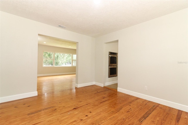 656 Lake Charm Dr, Oviedo, FL 32765 - empty room with baseboards, light wood finished floors, and a textured ceiling