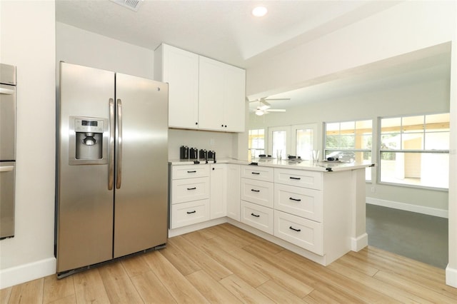 656 Lake Charm Dr, Oviedo, FL 32765 - kitchen featuring stainless steel appliances, a peninsula, white cabinetry, light countertops, and light wood-type flooring