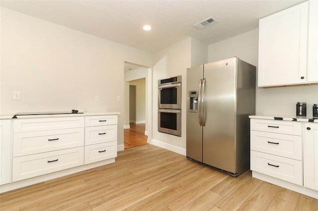 656 Lake Charm Dr, Oviedo, FL 32765 - kitchen with stainless steel appliances, white cabinetry, light countertops, light wood-style flooring, and recessed lighting