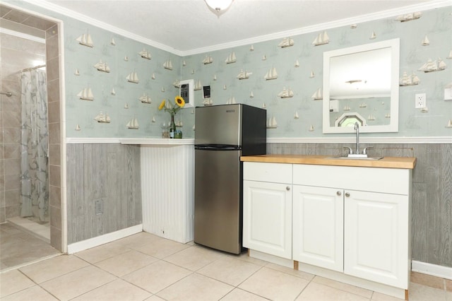 656 Lake Charm Dr, Oviedo, FL 32765 - kitchen featuring freestanding refrigerator, ornamental molding, a sink, white cabinetry, and wainscoting