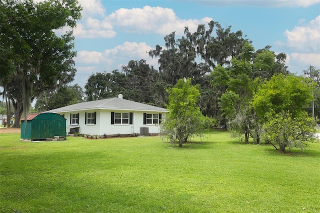 656 Lake Charm Dr, Oviedo, FL 32765 - rear view of house featuring cooling unit, a yard, a shed, an outdoor structure, and view of wooded area