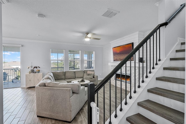 1123 Dora Parc Ln, Mount Dora, FL 32757 - living room featuring ceiling fan, a lit fireplace, crown molding, wood finished floors, and stairs