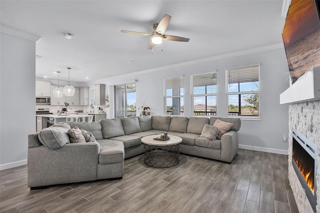 1123 Dora Parc Ln, Mount Dora, FL 32757 - living area featuring baseboards, ceiling fan, ornamental molding, wood finished floors, and a stone fireplace