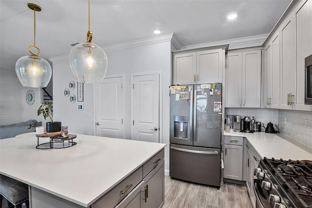 1123 Dora Parc Ln, Mount Dora, FL 32757 - kitchen with stainless steel appliances, gray cabinetry, crown molding, light countertops, and recessed lighting