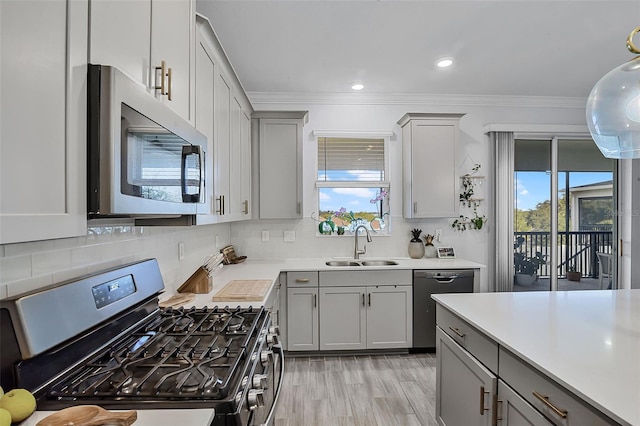 1123 Dora Parc Ln, Mount Dora, FL 32757 - kitchen with stainless steel appliances, gray cabinetry, a sink, light countertops, and decorative backsplash